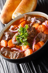 Vietnamese bo kho beef stew is packed with tender, fall-apart braised chunks of beef loaded with herbs, aromatics and a delicious broth closeup in bowl. Vertical