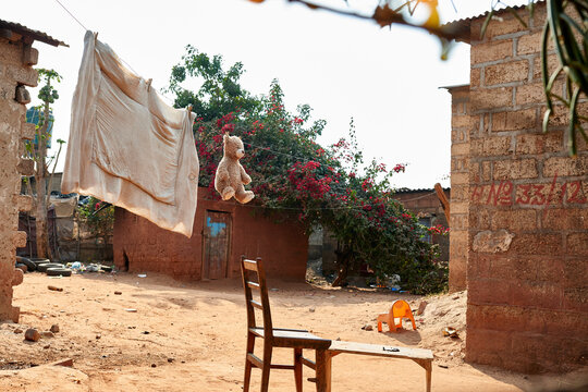 African street with duvet and Teddy Bear drying on rope