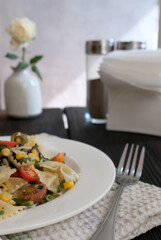 Vegeterian farfalle salad with tomato cherries. Vertical