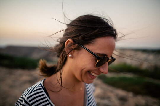Smiling woman enjoying the sunset in Algarve coast.