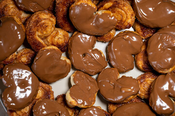 Palmier biscuits covered of chocolate. Top view assortment. Heart-shaped puff pastry, pig's ear, palm leaves cookies, elephant ears, french hearts, shoe-soles.