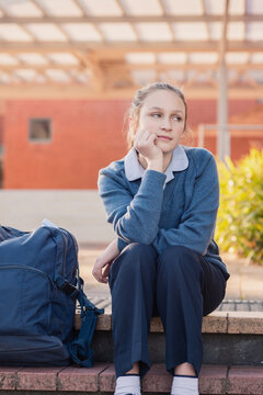 high school student bored of waiting on the steps after schoo