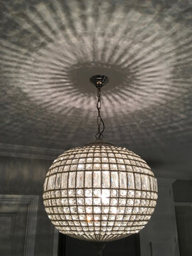 Crystal interior light fitting casting reflections on the ceiling at night.