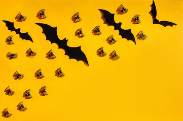 The backdrop for Halloween. On an orange background are black spiders and bats. A place for text.