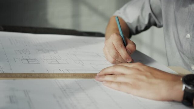 Male hands of an architect drawing a construction plan