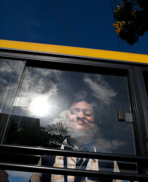 Teenage Girl Behind Glass Of A School Bus