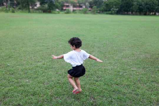 Energetic kid streatching hands and making fun at outdoor