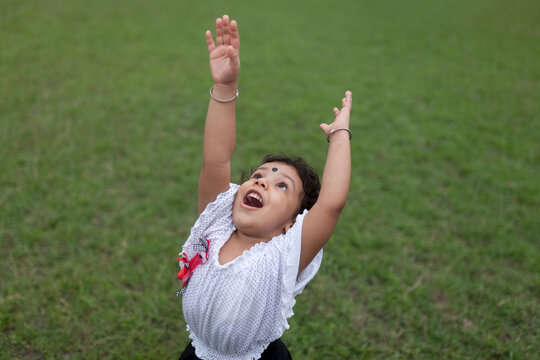 Energetic kid looking upward and streatching hands