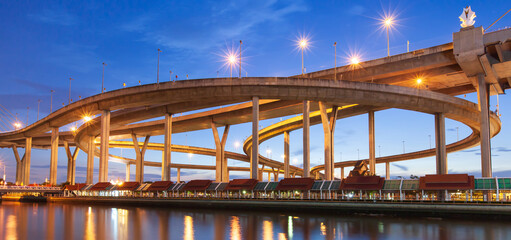 Highway interchange and suspension bridges at twilight.