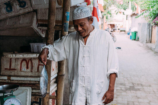 Indonesian Middleaged man runs a fish business on local market