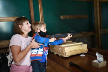Mother with son shoot air rifle