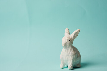 Festive white rabbit toy on a blue background with pastel colors Easter