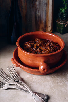 Pulled beef brisket in a terracotta pot.