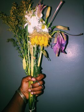 Woman holding a bouquet of dead flowers