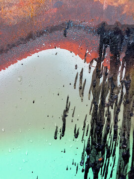 Close up of dripping black paint on rusty, metal trash canister