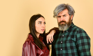 Fashion couple in love. Fashionable couple posing. Enjoying spring time together. Street style. Today is good day. Hipster couple. Bearded man with dyed hair checkered shirt and stylish girl in coat