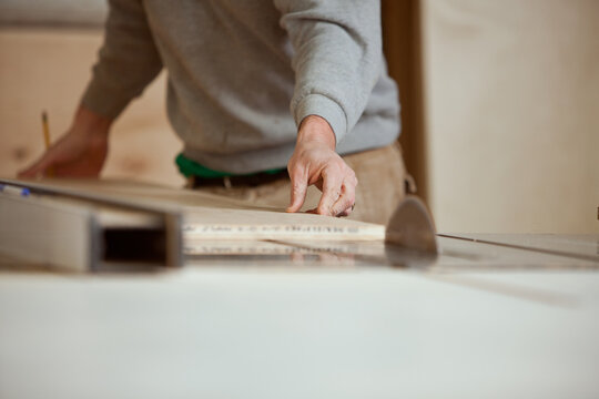 Woodworking: Man Using Table Saw to Cut Plywood