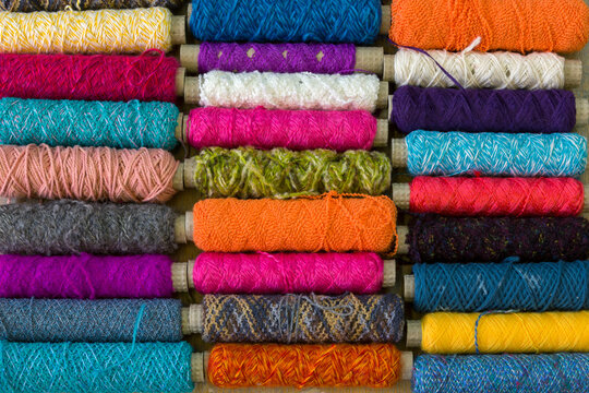 Spindles with different coloured yarn covering the frame