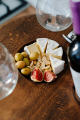 Camembert cheese, olives and nuts on the wine table