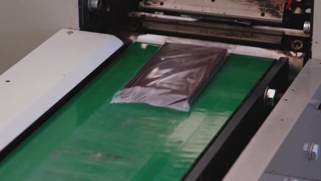 Factory made packaged chocolate bar. Automatic packaging chocolate process. Dairy factory, production of chocolate bars in wrappers.Modern technologies. 