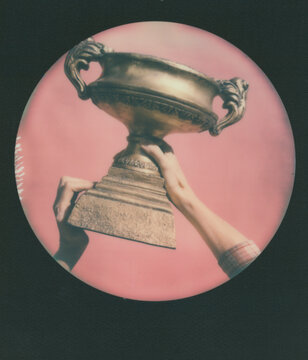 Polaroid Print Of Hands Holding A Gold Trophy