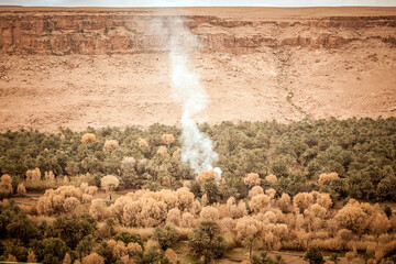 Smoke coming from desert oasis in south Morocco, hidden by the mountain desert - Powered by Adobe