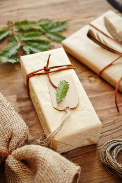 Gift with homemade wrapping paper with leather twine and pine