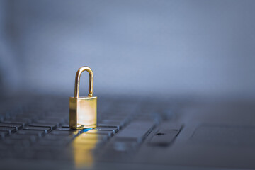 Background image of golden metal lock on keyboard, computer security