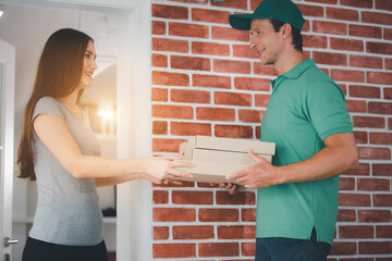 Delivery man employee in green cap t-shirt ready to send delivery food box in front of custom office. Delivery and shopping online concept.