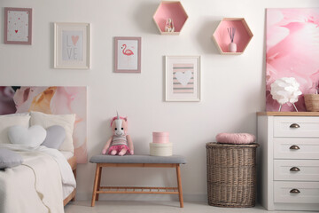 Modern teenager's room interior with comfortable bed and beautiful pictures