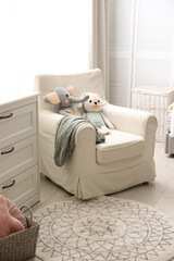 Comfortable armchair in modern baby room interior