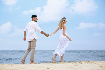 Fototapeta na wymiar Happy couple having romantic walk on beach
