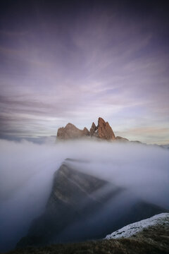 a sea of clouds floating over a mountain range at sunset - seced