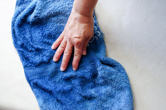Old women hand whiping blue dirty cloth to clearn the house floor