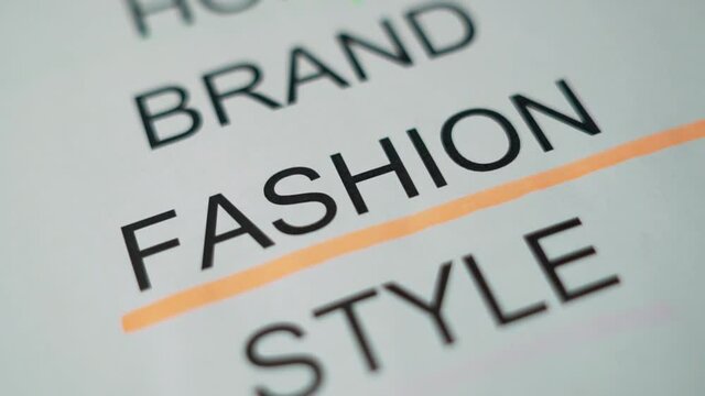 Underline Highlight a Large Printed Word Text Sign on a Piece of Paper "FASHION" with a Orange Marker. Concept of the Fashion.