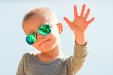 A Happy child in glasses from the sun on nature in the park travel