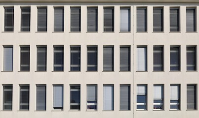 Fototapeta premium White facade of modern office building with long vertical PVC windows. Background and texture 