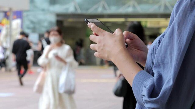 スマホを操作する若い女性の手元