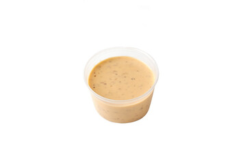 peanut sauce in a plastic container on an isolated white background