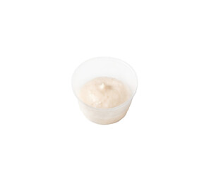 cream sauce in a plastic container on an isolated white background