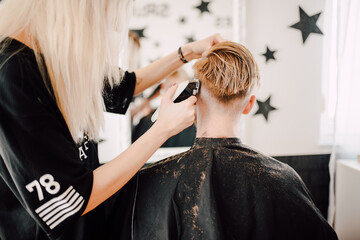 Female hairdresser giving a haircut to a client in the salon
