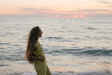 Young beautiful woman posing on a sunset beach.