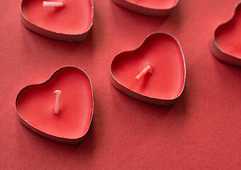 Hearth shaped candles on red background. love background