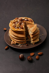 stack of pancake with syrup and nuts