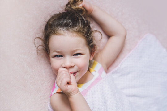 Beautiful little girl sucking her tumb looking relaxed and happy