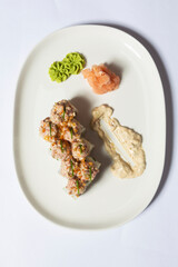Steak tartare sushi roll served on a white plate