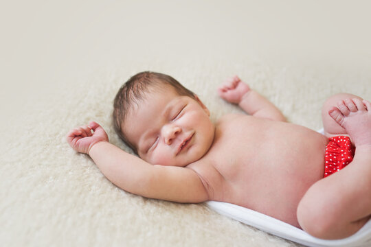 A cute sleeping newborn baby smiling