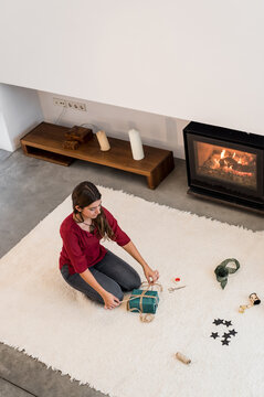 Girl making christmas presents in front of the chimney