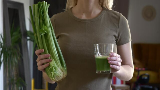 woman with celery juice in a glass at home