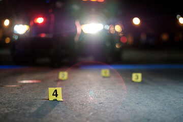 Shell casings are marked with evidence tags at a crime scene